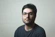 man in black crew neck shirt wearing black framed eyeglasses