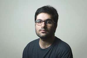 man in black crew neck shirt wearing black framed eyeglasses