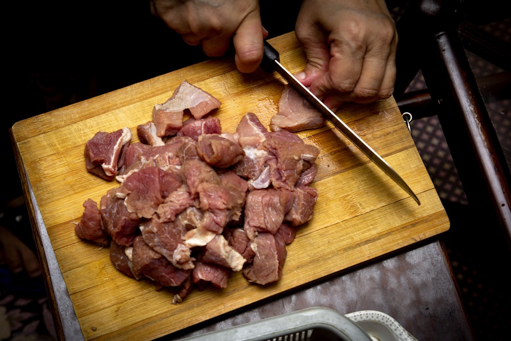 viande tranchée sur une planche à découper en bois brun