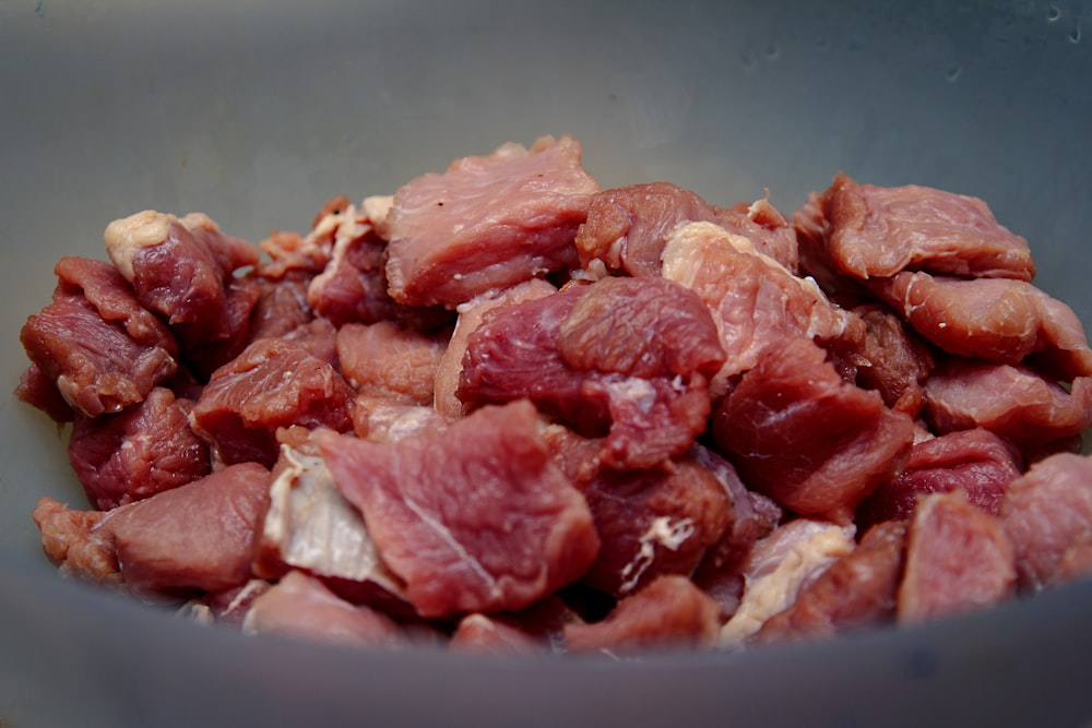 viande crue sur bol en céramique bleue