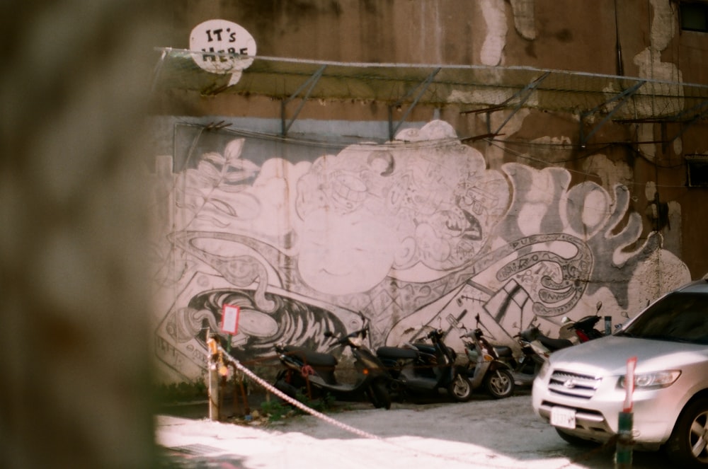 black motorcycle parked beside wall with graffiti