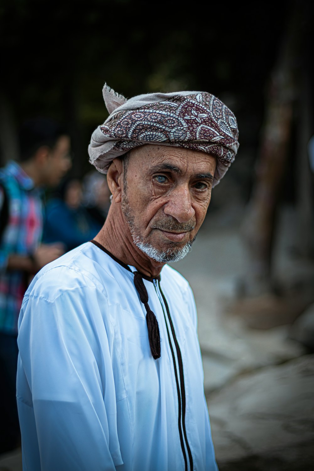 man in blue dress shirt wearing white and black floral bandana