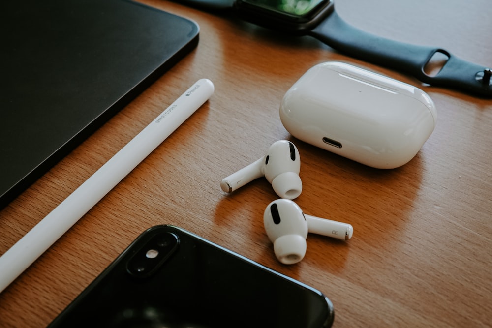 white apple earpods beside black iphone 5