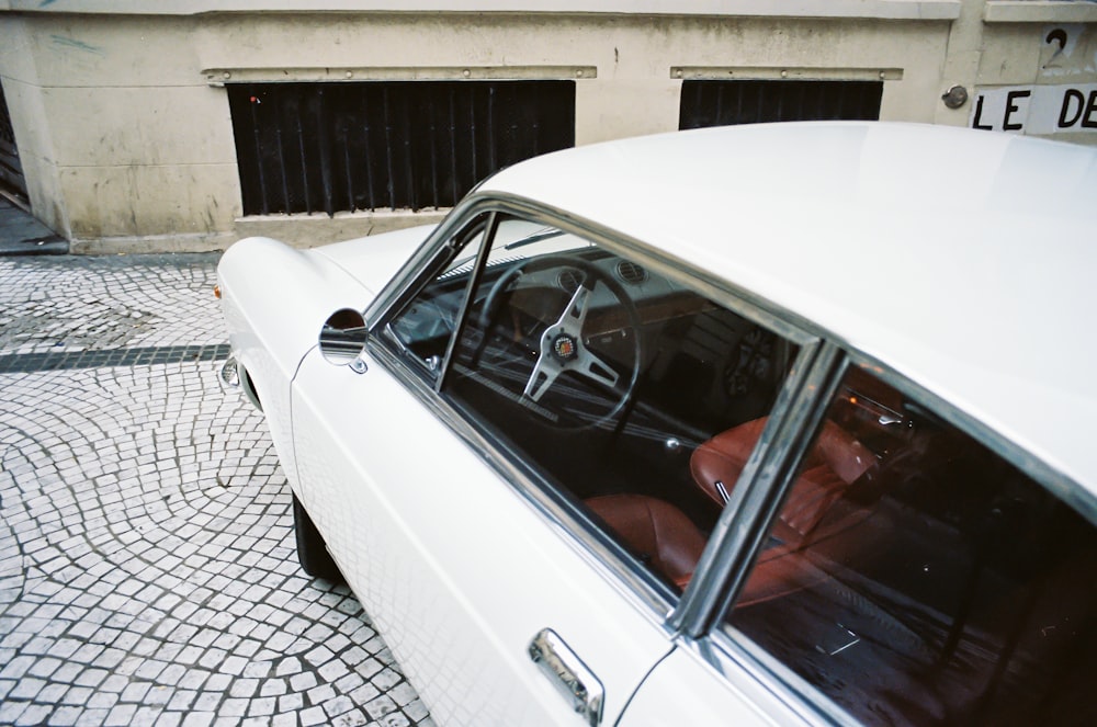 white car parked near white building