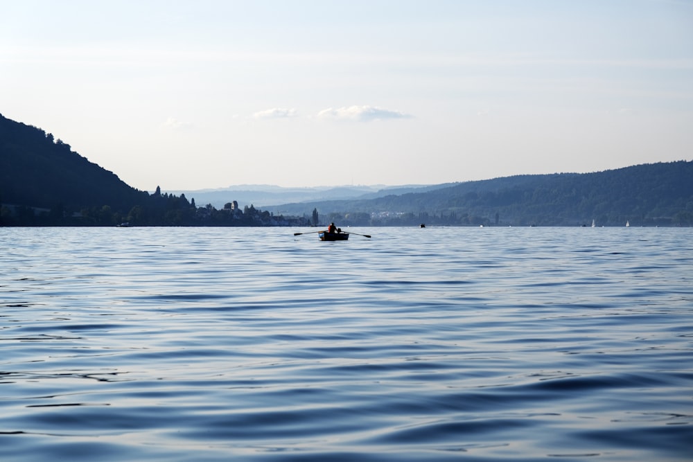 2 people riding on boat on sea during daytime