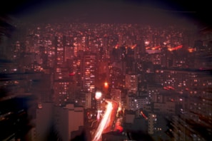 A bustling cityscape at night filled with lights.