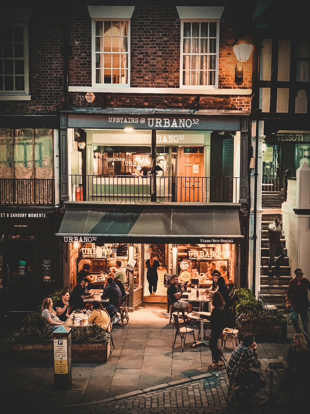 pessoas sentadas na cadeira fora do restaurante durante o dia