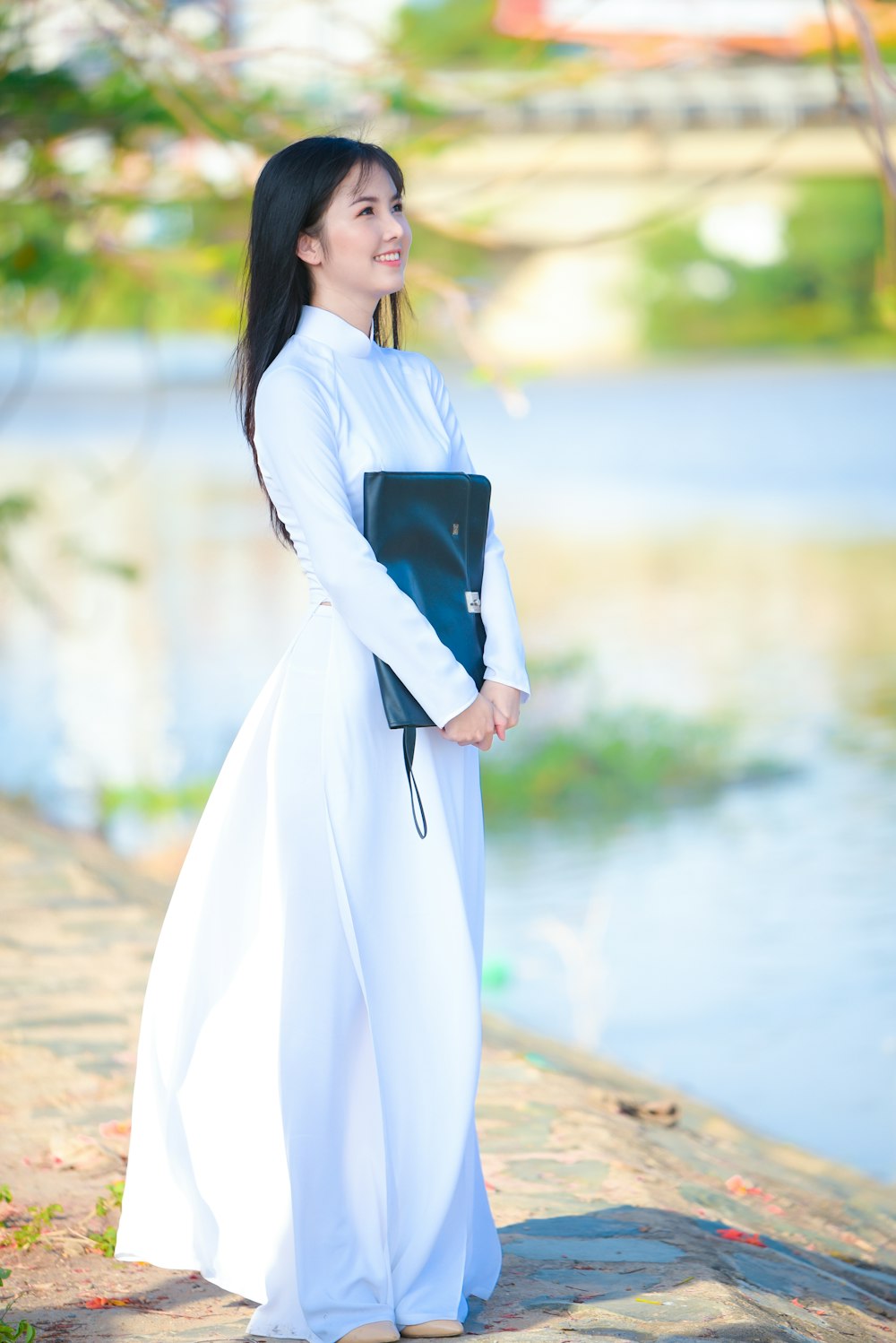 woman in white long sleeve dress holding black book