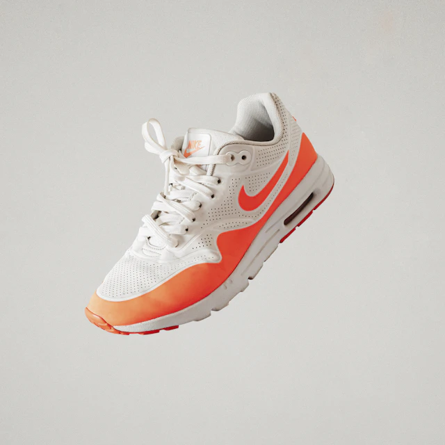 A white and red Nike athletic shoe photographed on its own