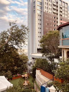 Sunlit view of Rivelle Tampines EC's sleek exterior with lush greenery surrounding the building.