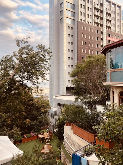 Sunlit view of Rivelle Tampines EC's sleek exterior with lush greenery surrounding the building.