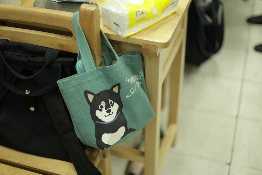 green and white tote bag on brown wooden table