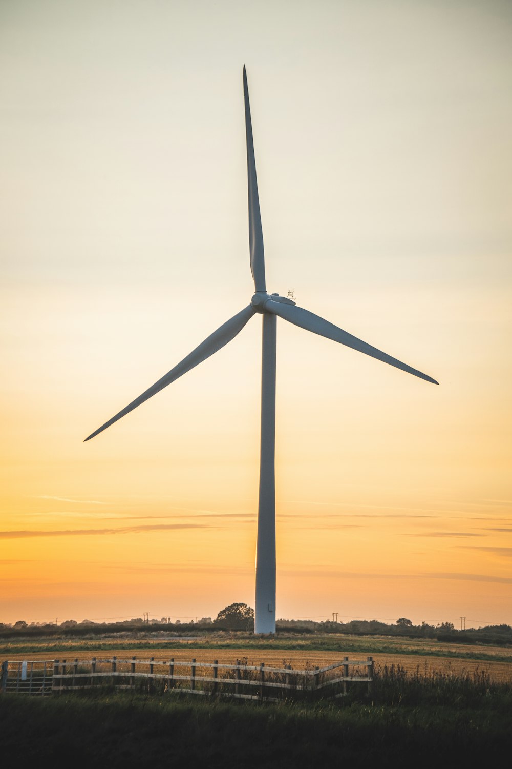 white wind turbine during sunset
