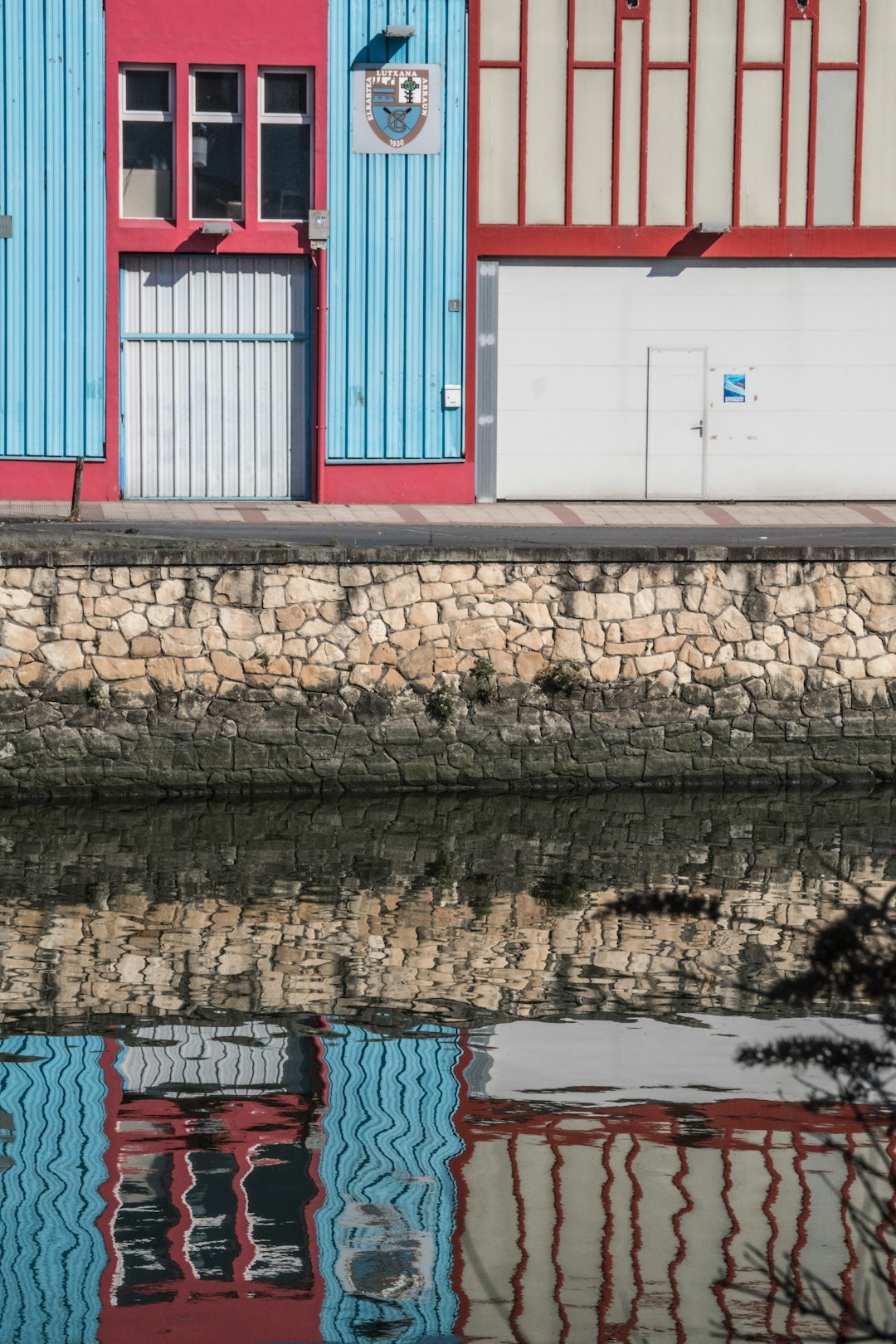 red and white wooden house beside body of water during daytime