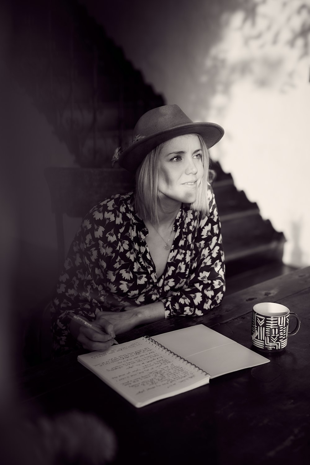 woman in black and white floral long sleeve shirt wearing brown fedora hat