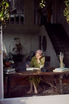 A serene boho chic woman writing in a journal by soft natural light, surrounded by taupe and pink accents.