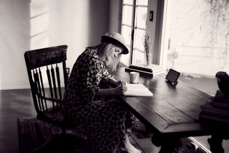 woman in black and white floral dress sitting on chair