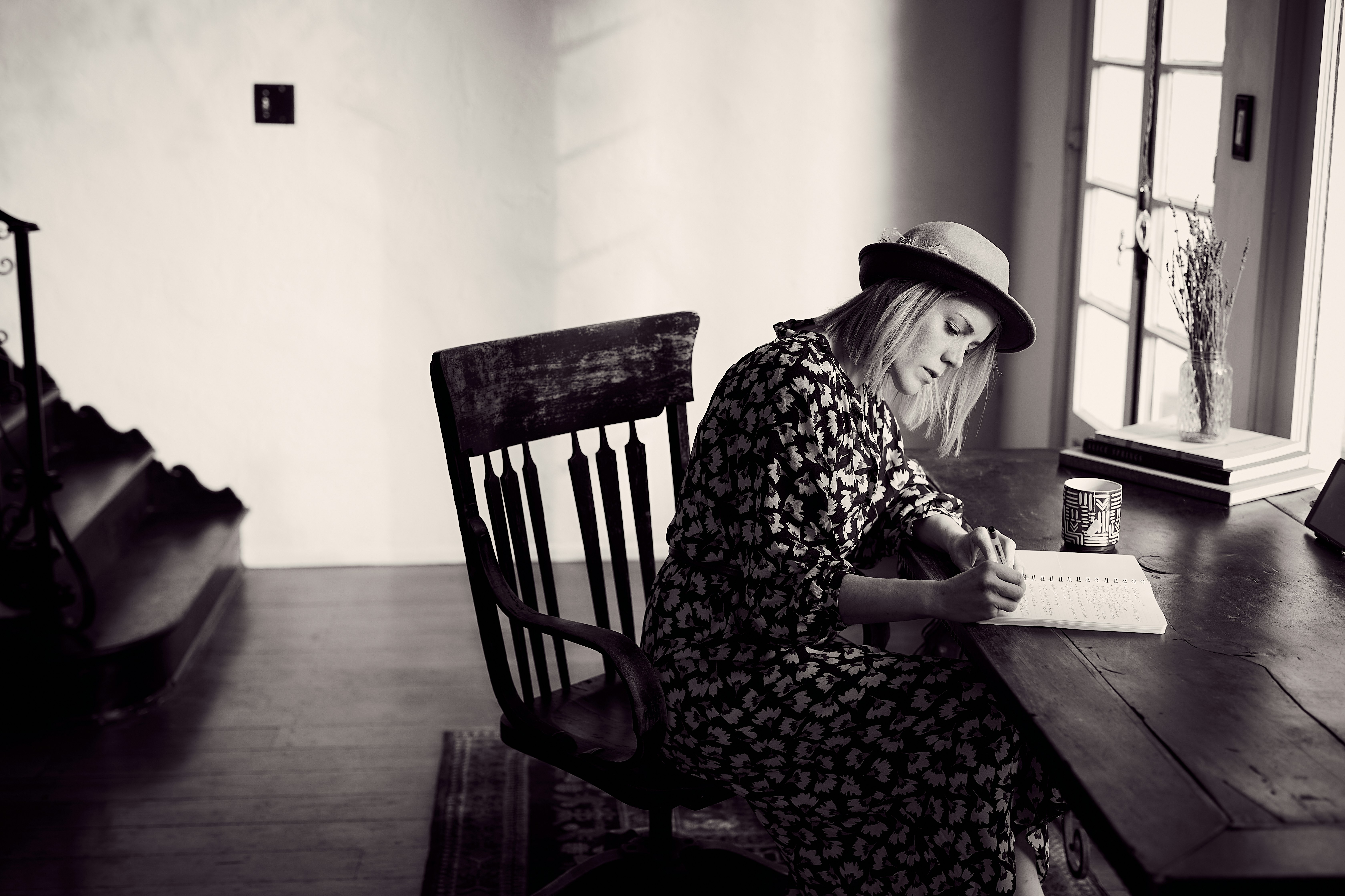 woman in black and white floral dress sitting on chair