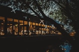 Wide shot of the restaurant lit warmly against the twilight bay waters.