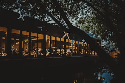 Wide shot of the restaurant lit warmly against the twilight bay waters.