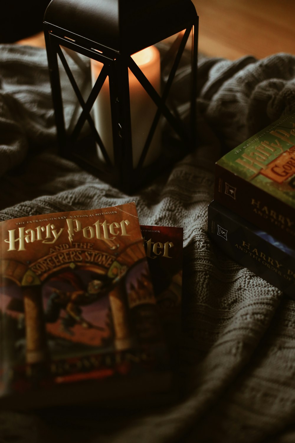 harry potter books and a lantern on a bed