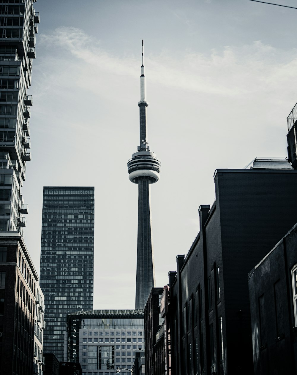 gray tower between buildings during daytime