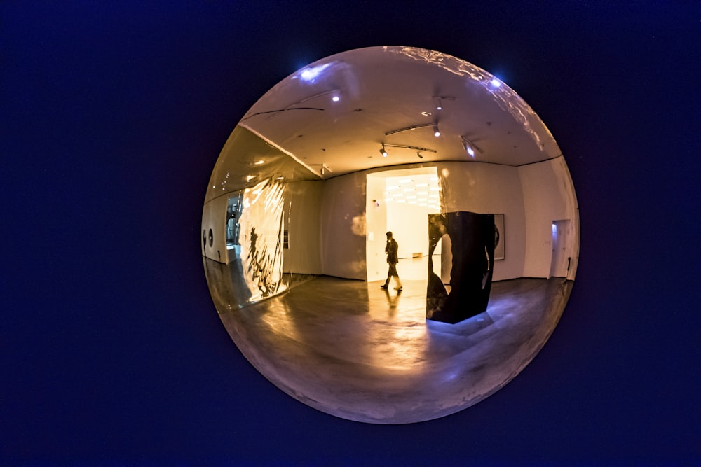 clear glass ball with reflection of man standing on the floor