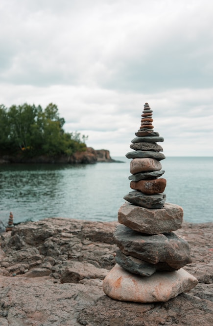 stack of stones near body of water during daytime