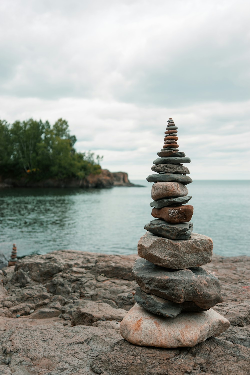 stack of stones near body of water during daytime