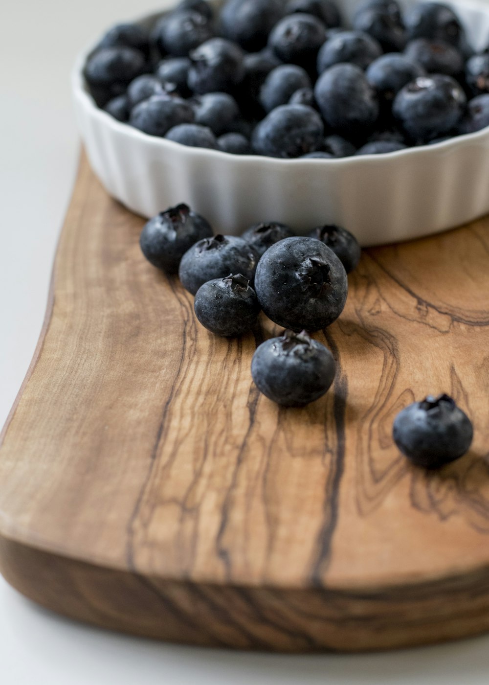 black berries on white ceramic bowl