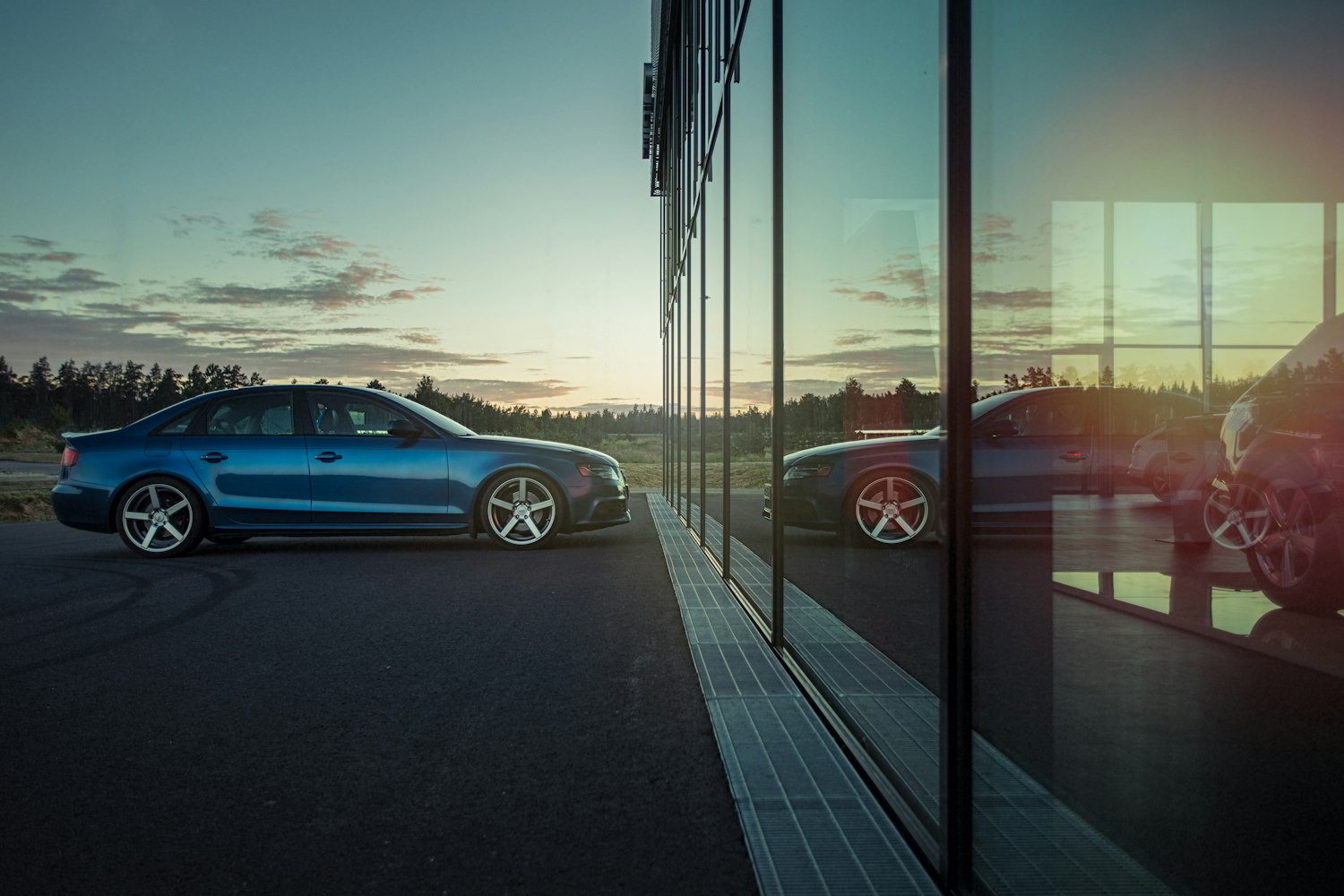 Audi A4 in front of a mirrored window.