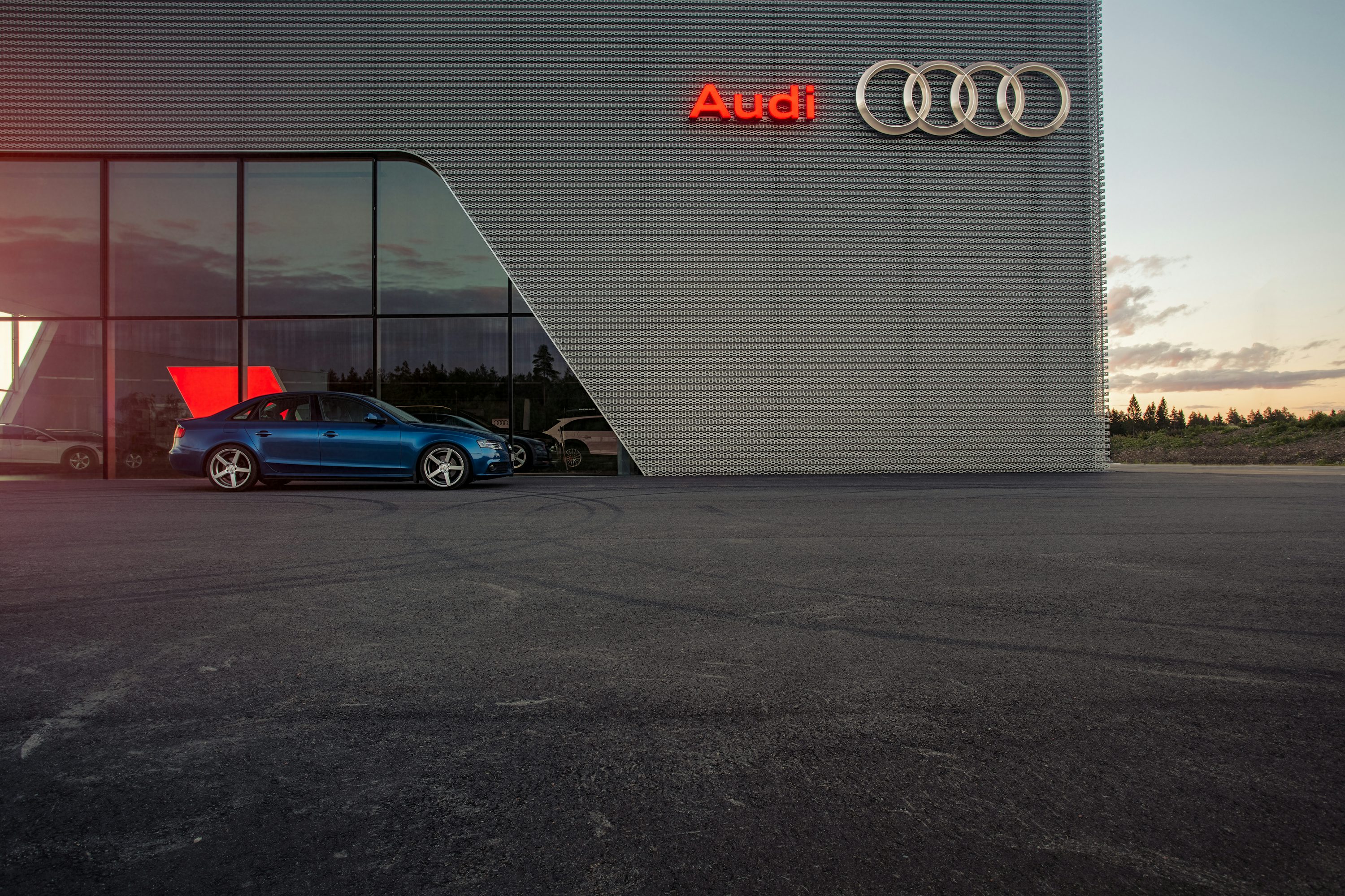 blue porsche 911 parked beside white wall