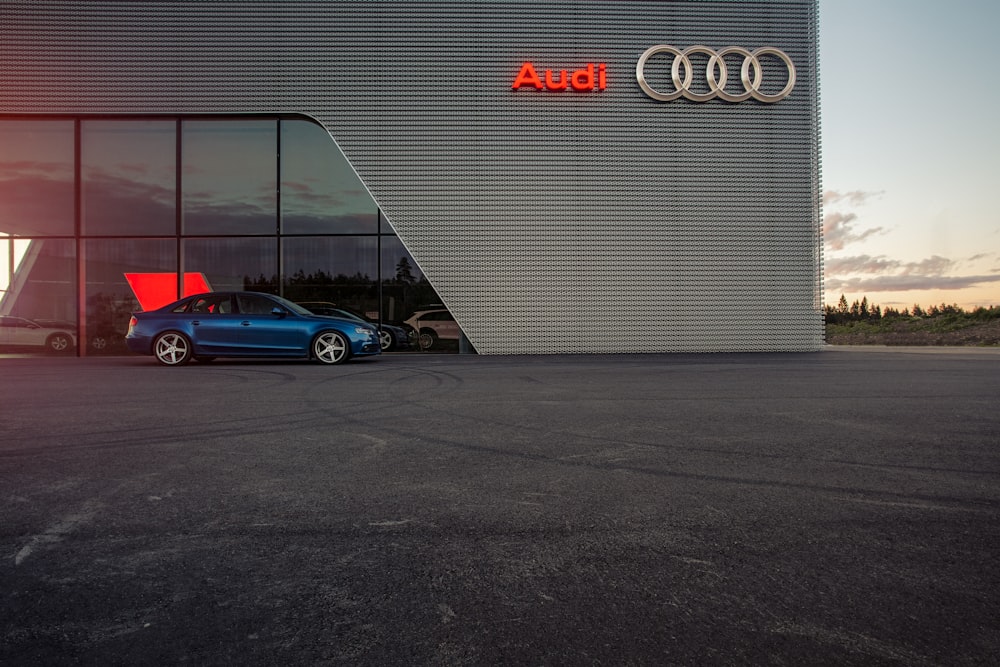 Blauer Porsche 911 parkt neben weißer Wand