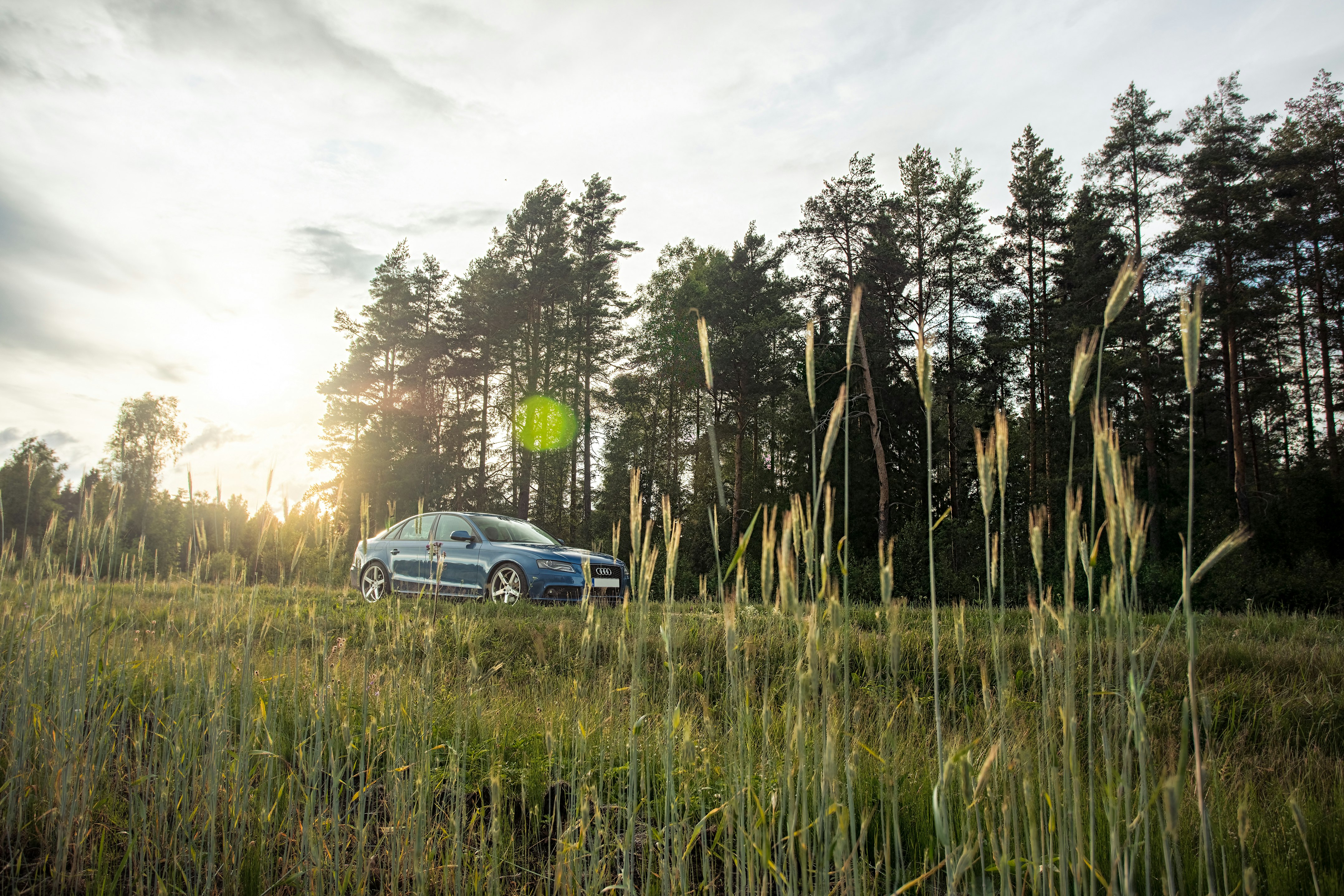 blue car parked beside green grass field during daytime