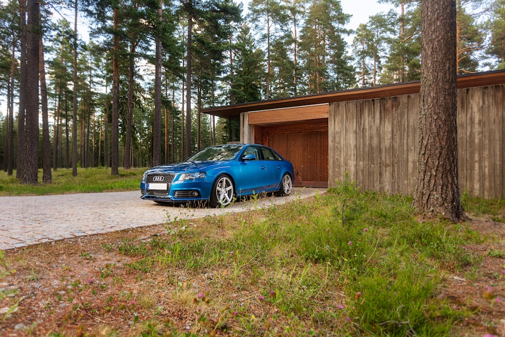 blue bmw m 3 parked near brown wooden house