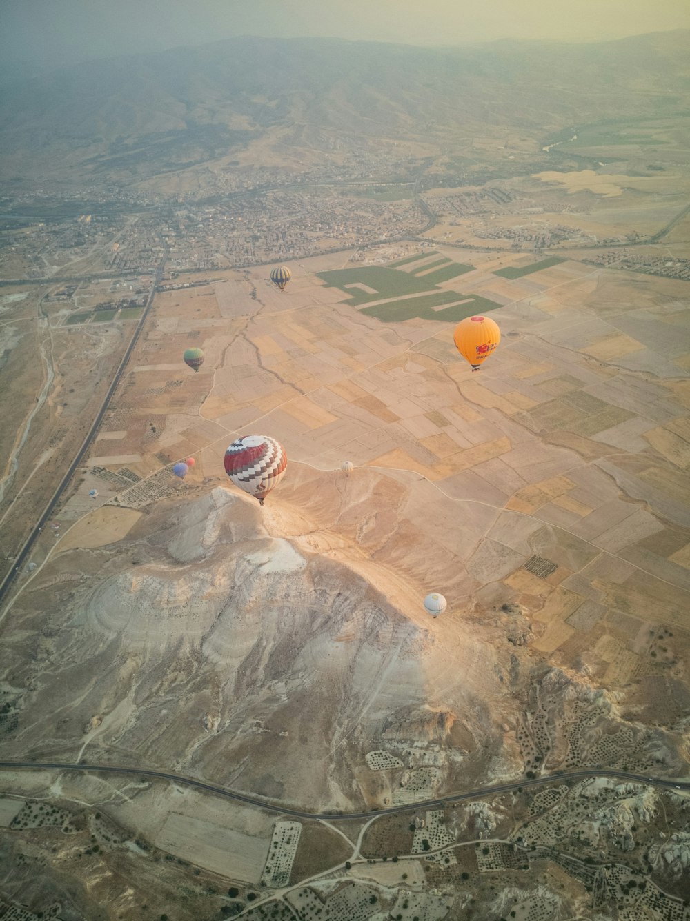 vista aérea de balões de ar quente no campo de grama verde durante o dia