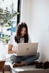woman in white shirt using laptop