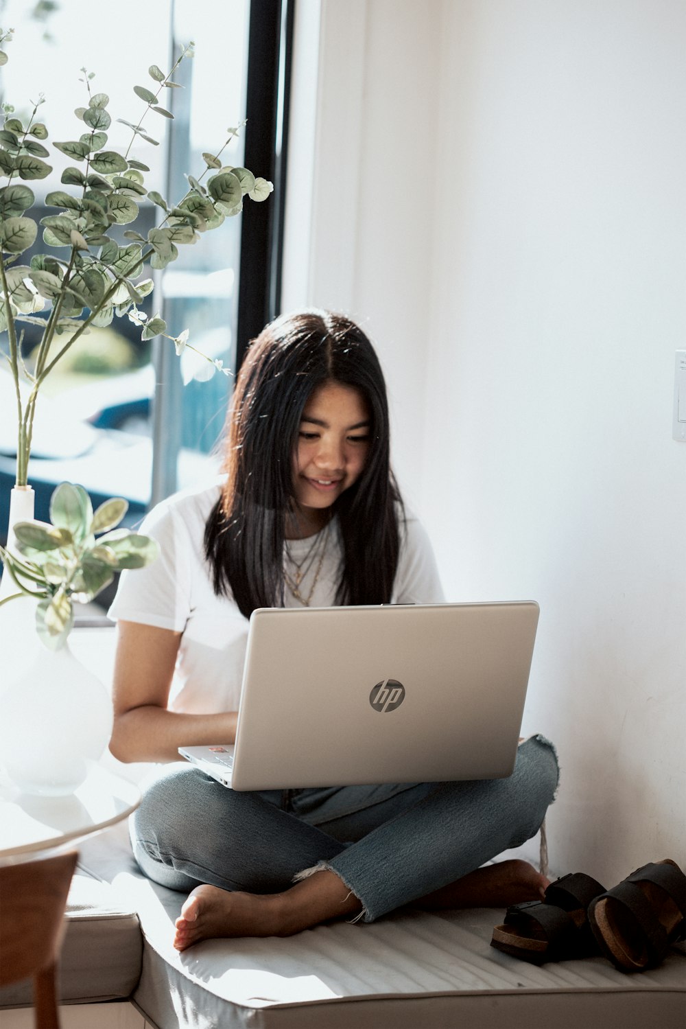 woman in white shirt using laptop