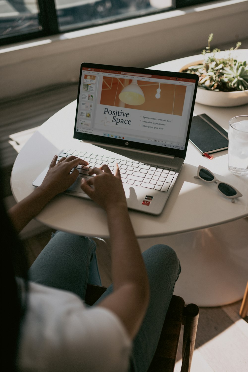 person using laptop on white table