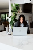 woman in gray sweater using laptop