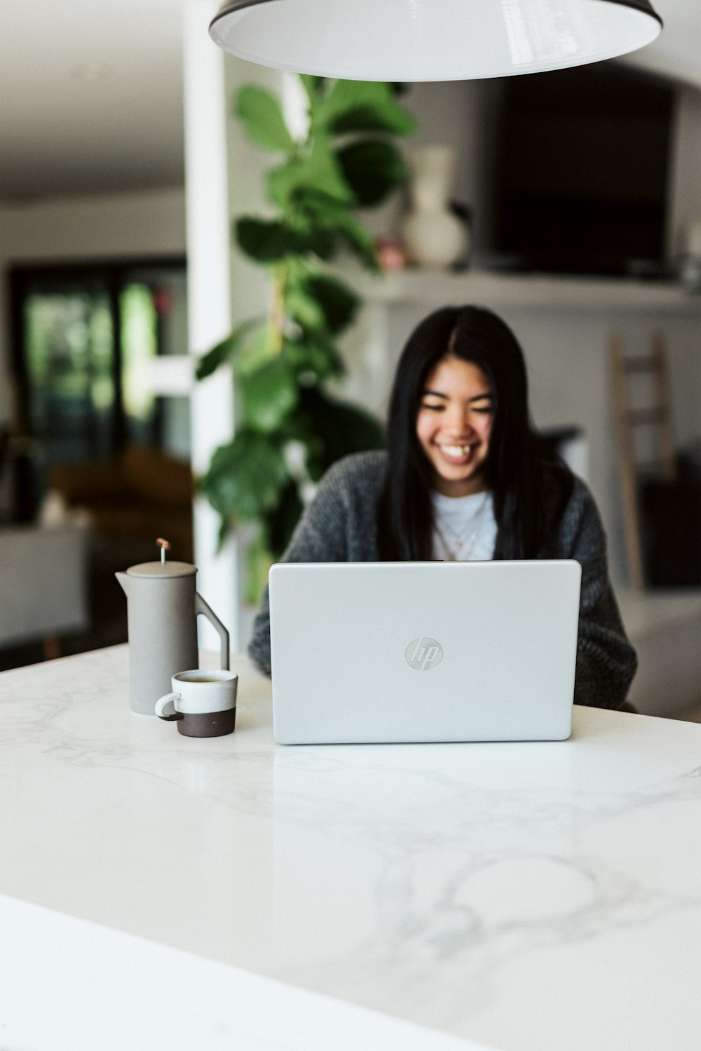 Mujer en suéter gris usando computadora portátil