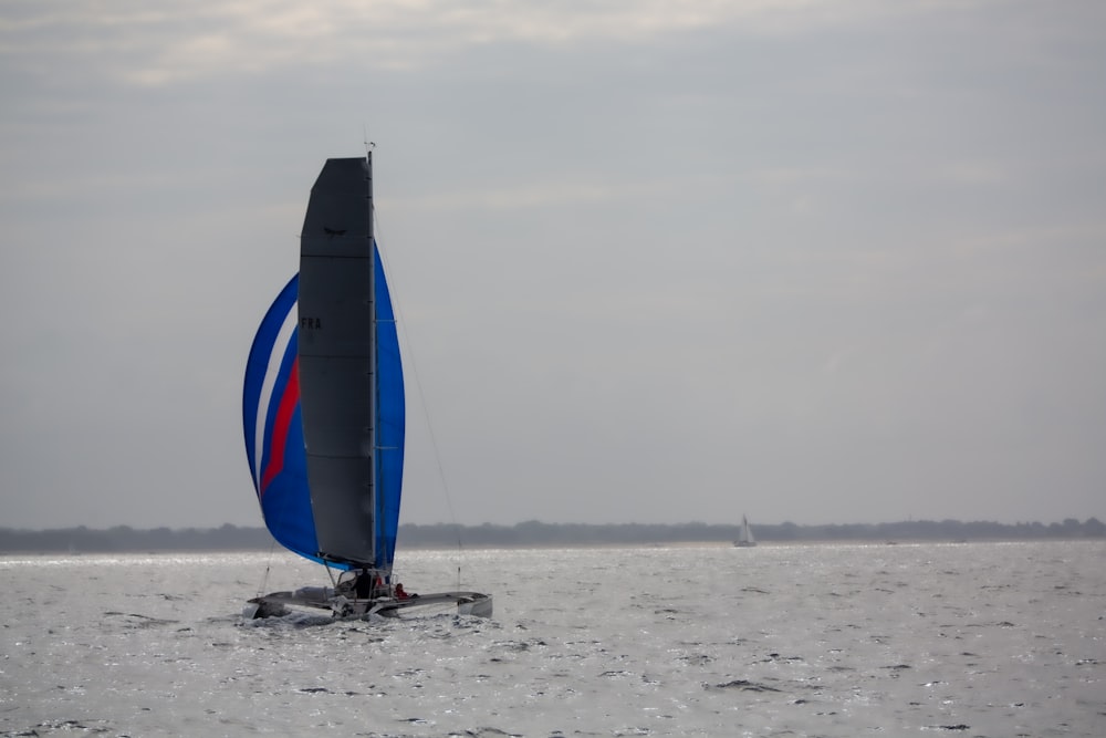 blue sail boat on sea during daytime