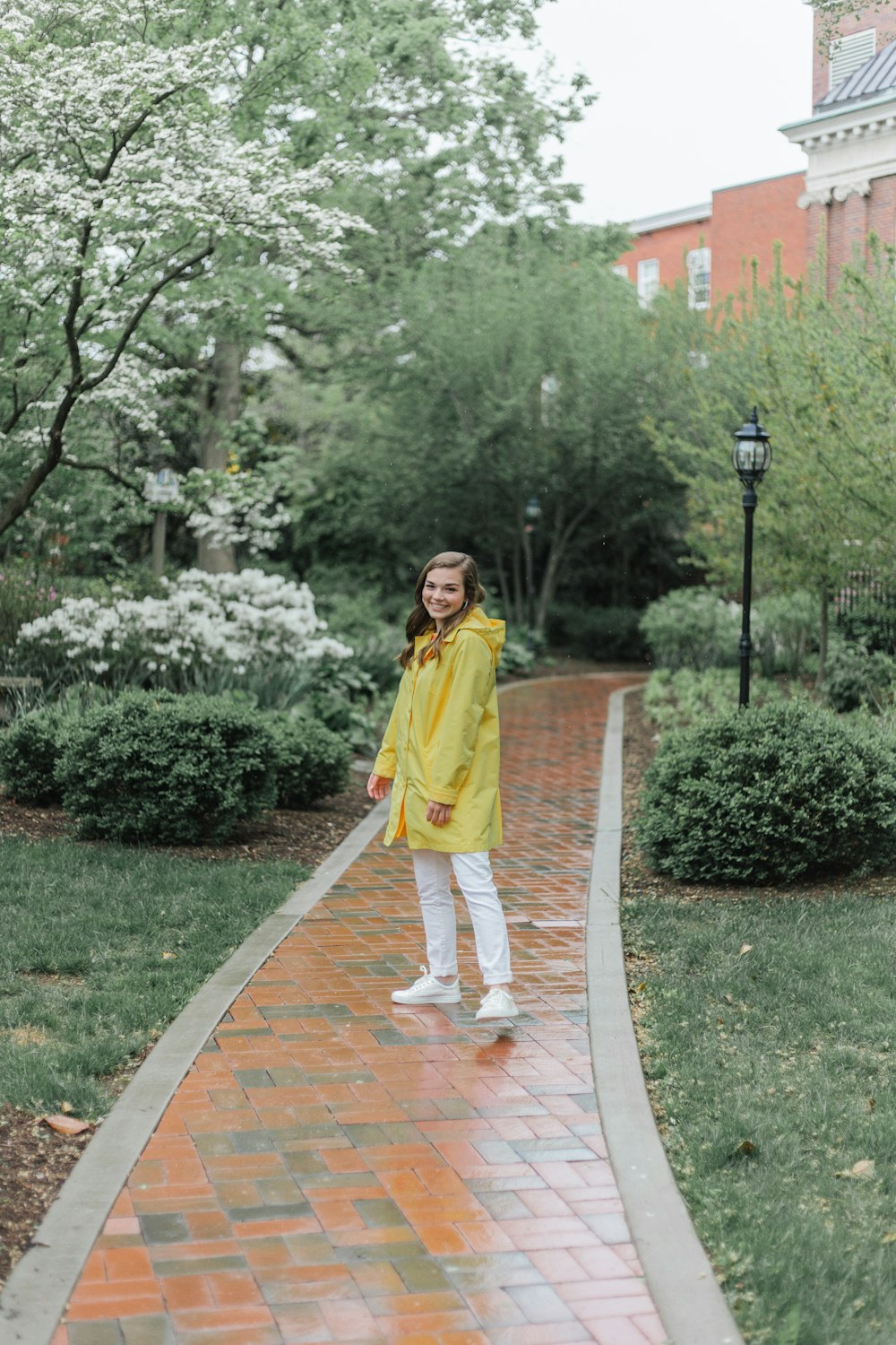 woman in yellow robe standing on brown concrete pathway