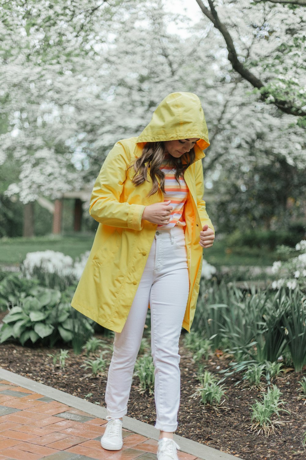 woman in yellow hoodie and white pants holding yellow umbrella