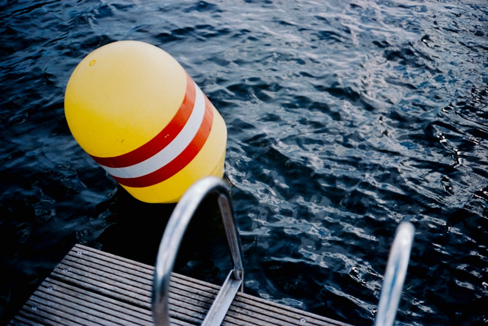 yellow and white striped ball on stainless steel bar