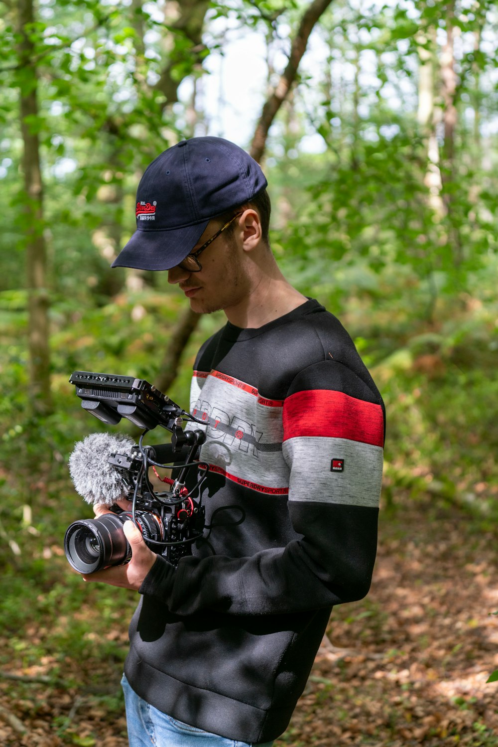 man in black and red long sleeve shirt holding black dslr camera