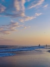 silhouette of person standing on beach during sunset