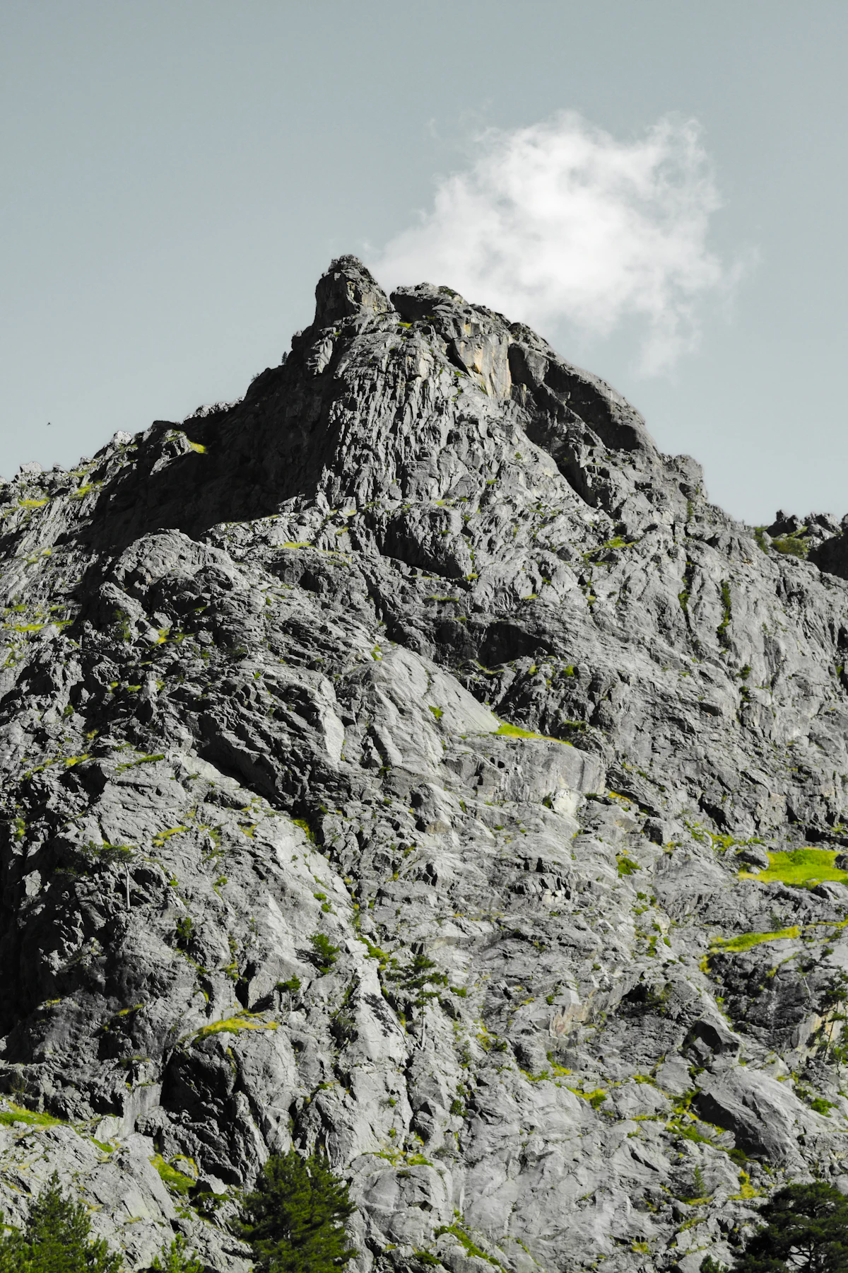 A bare rock peak above the Restonica valley against a pale sky