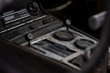 Close-up of a vintage car dashboard showing worn controls and gauges.