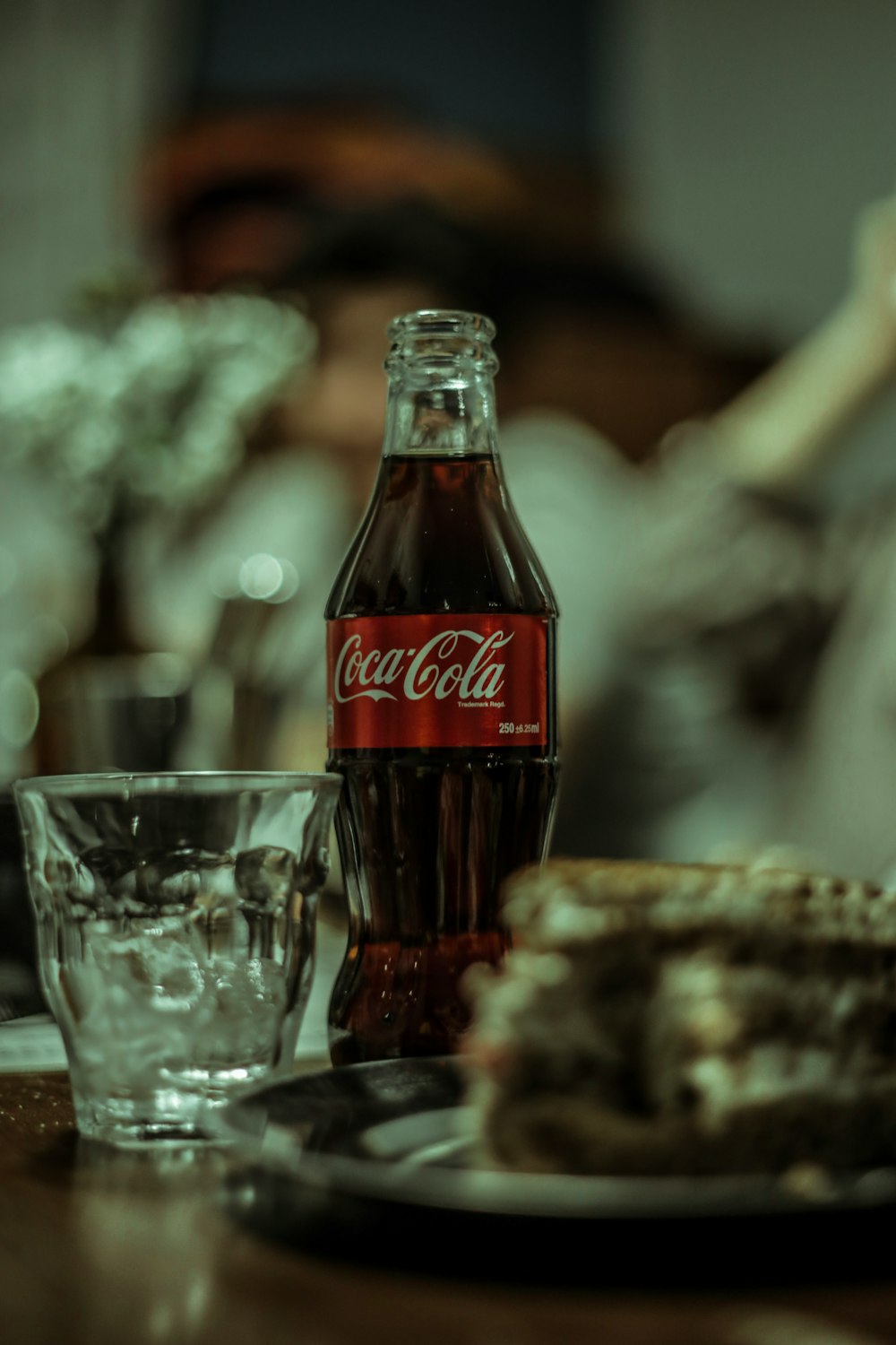 coca cola bottle beside drinking glass